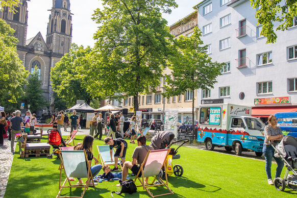 Tag der Städtebauförderung: Grüne und gut besuchte Veranstaltungsfläche auf dem Stiftsplatz mit der Stiftskirche im Hintergrund.