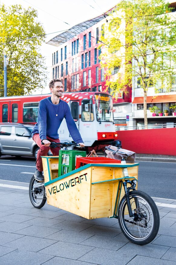 Ein Mann fährt mit seinem Lastenfahrrad durch Bonn