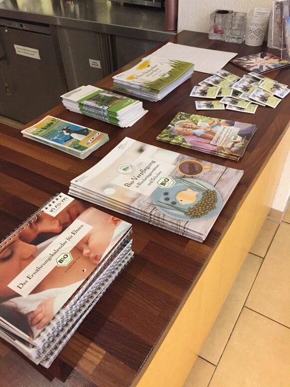 Auf einem Tisch liegen Broschüren und Flyer zu biologischer Ernährung.