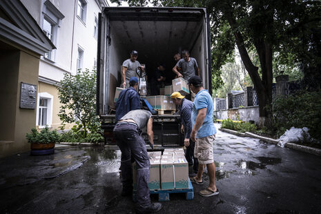 Mehrere Männer laden Pakete aus einem Lkw aus