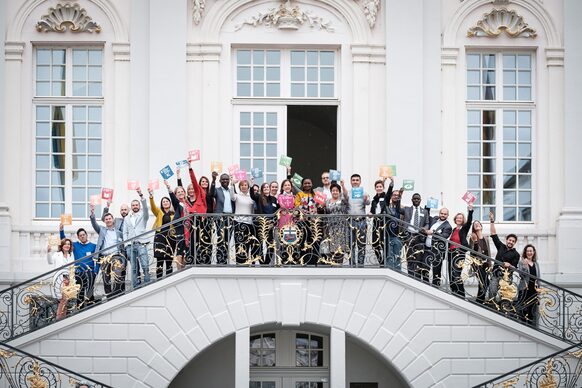 Das Foto zeigt die Teilnehmenden der SDG Partnerschaftskonferenz auf der Freitreppe am Alten Rathaus