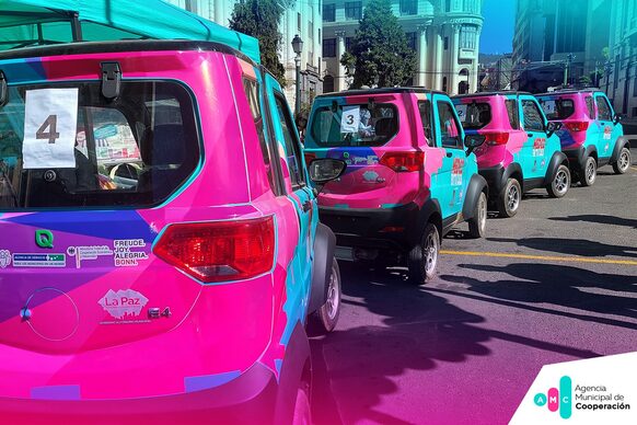Die pinken Elektroautos fahren mit der städtischen Dachmarke Bonns durch La Paz