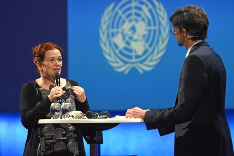 Oberbürgermeisterin Katja Dörner mit einem Mikrofon in der Hand im Gespräch mit einem Mann