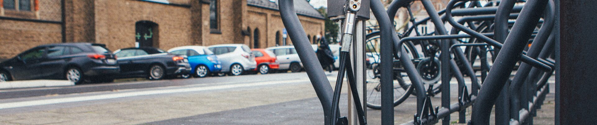 Das Foto zeigt eine Frau mit einem Lastenrad vor einer Fahrrad-Abstellbox.