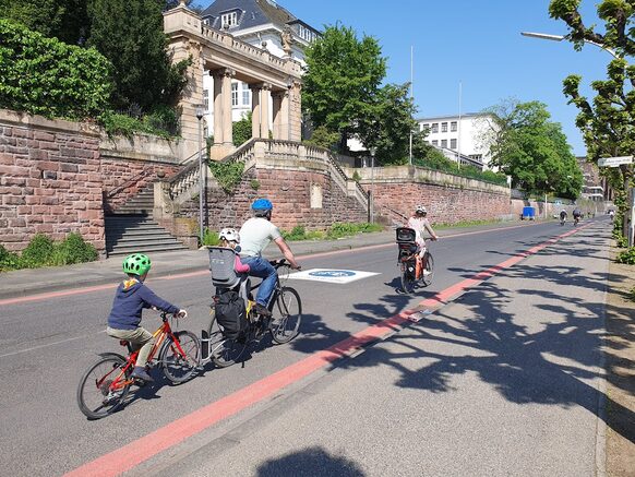 Das Bild zeigt die neue Markierungsart von Fahrradstraßen in Bonn mit roten Linien am Fahrbahnrand.
