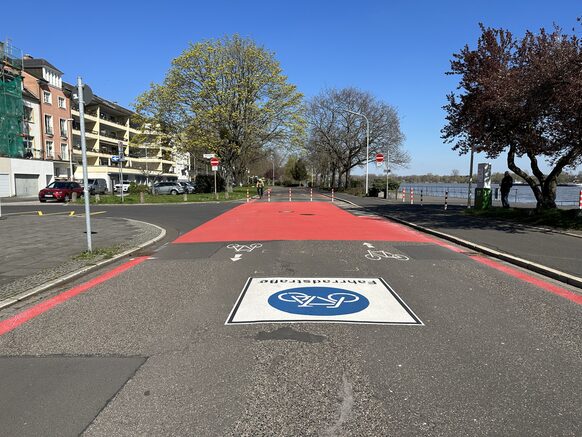 Das Bild zeigt eine Fahrradstraße mit neuen, roten Linien am Rand.