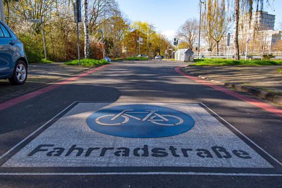 Das Bild zeig eine Fahrradstraße, die auf der Fahrbahn das Symbol eines Fahrrads zeigt.
