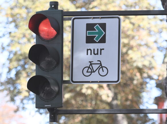Das Bild zeigt ein Schild, auf dem ein grüner Pfeil für Fahrradfahrer*innen zu sehen ist.