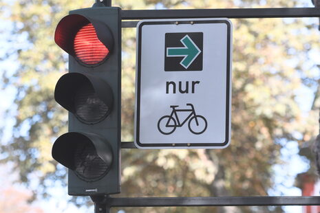 Das Bild zeigt ein Verkehrsschild, auf dem ein grüner Pfeil für Fahrradfahrer*innen zu sehen ist.