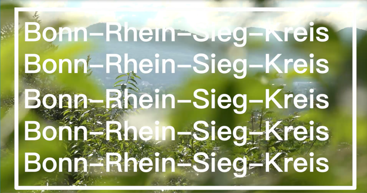 Schriftzug Bonn-Rhein-Sieg-Kreis vor Landschaftsaufnahme des Siebengebirges