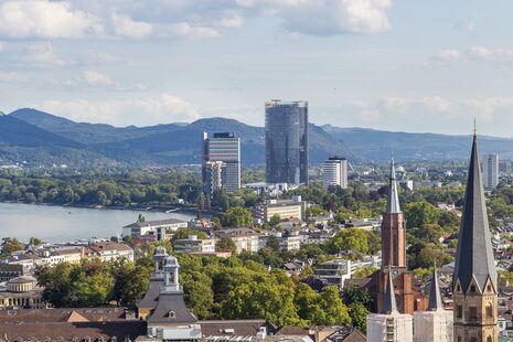 Blick vom Stadthausdach auf die Bonner Innenstadt. Im Hintergrund sind Posttower, UN-Tower und Siebengebirge.