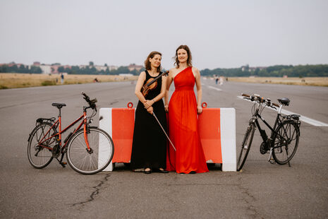 Foto der Künstlerinnen Mareike Neumann und Anna-Luise Oppelt mit Fahrrädern.