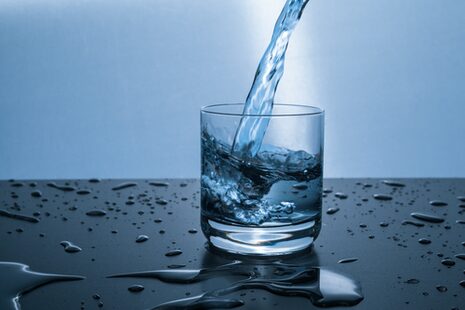 Mineralwasser wird in ein Glas eingegossen
