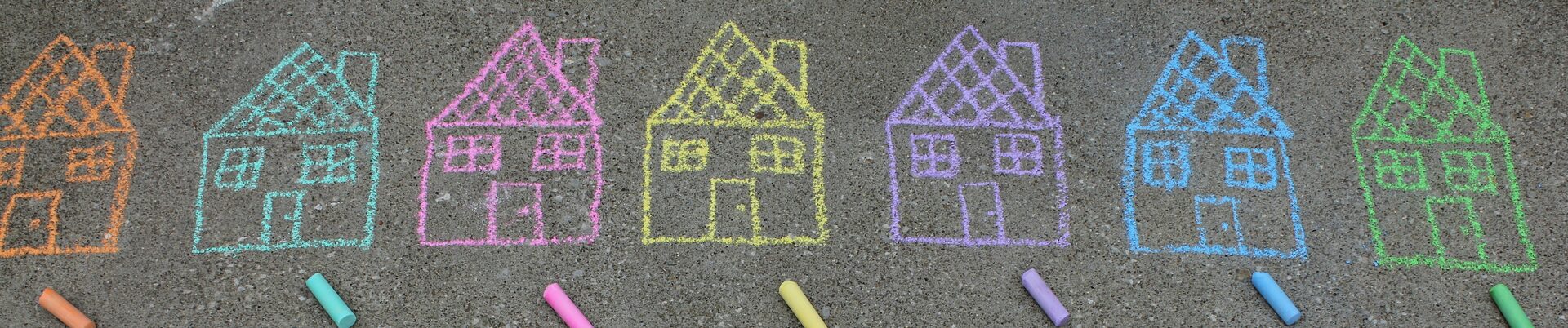 Mit bunter Kreide auf Straßenbelag gemalte Häuschen